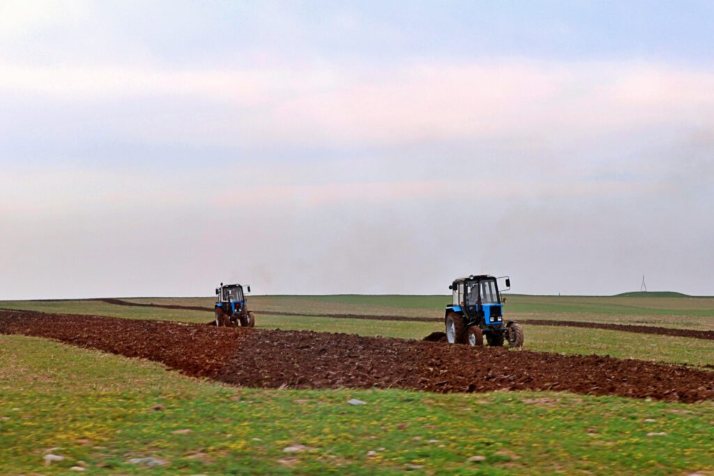 Info Shymkent - Two tractors preparing the fields near the Sairam-Ugam Mountain Range